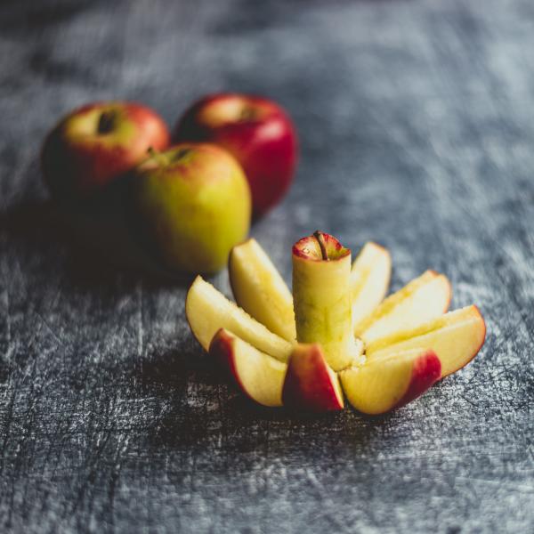 An image of a sliced apple on a grey tablecloth.
