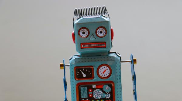 Image of grey retro robot toy with coil on head