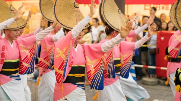 Bon dancers in pink and white traditional costumes with straw hats