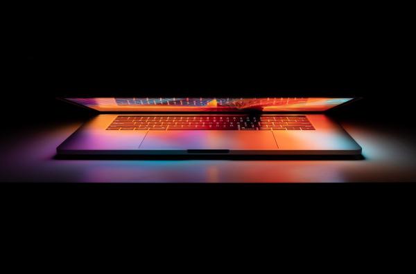 Image of laptop semi open illuminating a surface