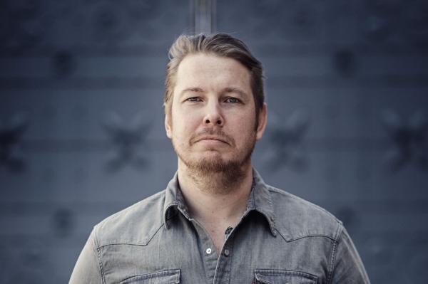 Headshot of author Fredrik Backman against a gray wall