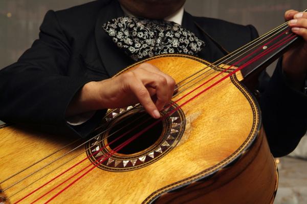 A mariachi player playing the guitar