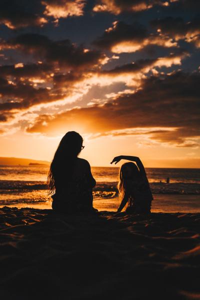 Picture of mother and daughter doing yoga on the beach