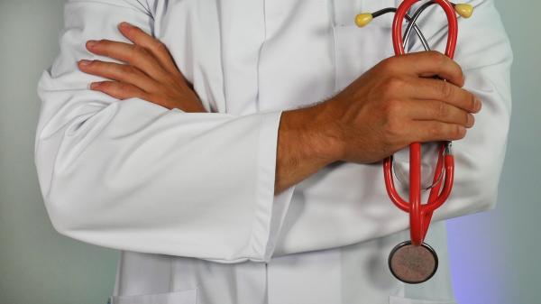 Doctors body holding a red stethoscope 