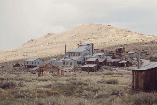 Seemingly abandoned mining town with small mountain in background