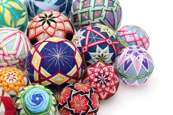 A collection of embroidered thread balls in different shapes and colors.