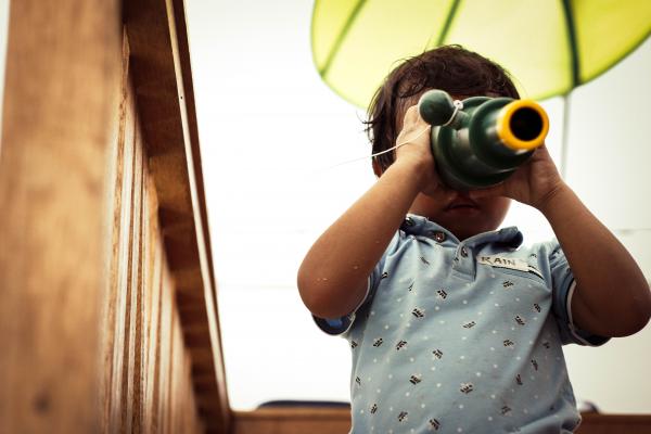 Child outside looking through a monoscope.