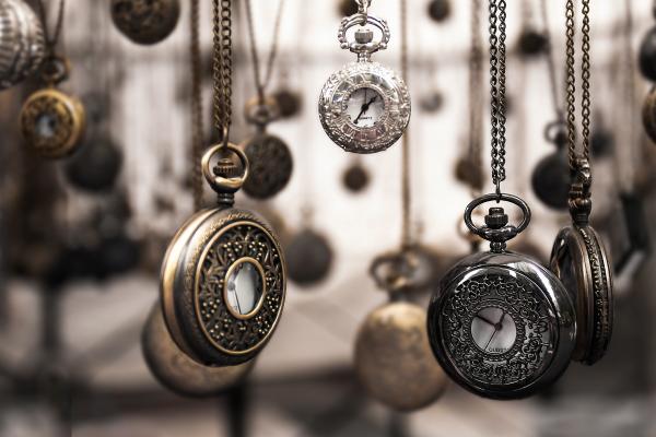 Various sizes and types of pocket watches hanging from above