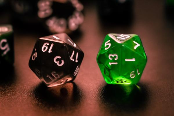 Two 20-sided dice sitting on a table.