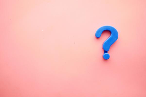 Small blue question mark on a pink background.