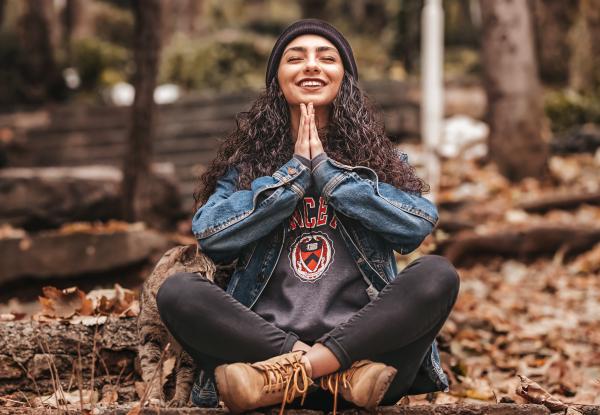 A girl meditating in the woods and smiling