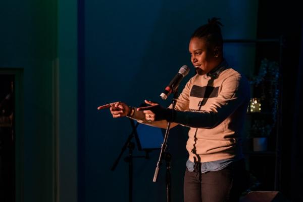Adams County Poet Laureate Kerrie Joy speaking in front of a microphone