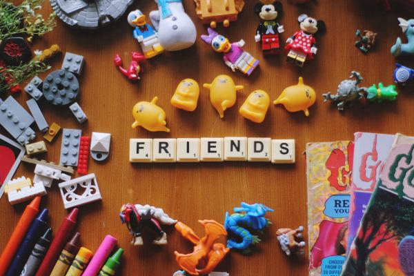 A collection of small colorful toys, including Scrabble letters spelling "friends"