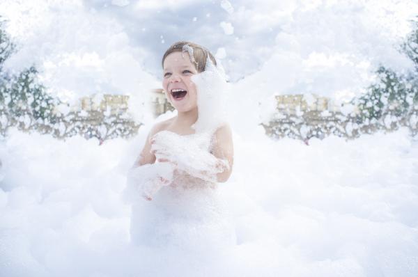 Image of child playing in foam bubbles.