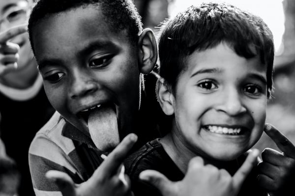 two boys making silly faces to the camera, in black and white
