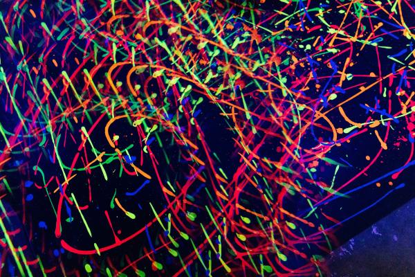 neon paint splatters glowing under a blacklight