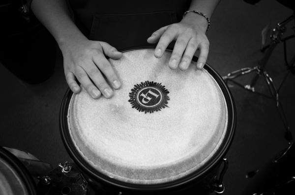 A pair of hands playing a drum, black and white photo
