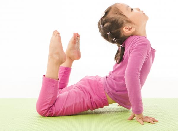 A girl doing a yoga pose/Una niña haciendo una pose de yoga